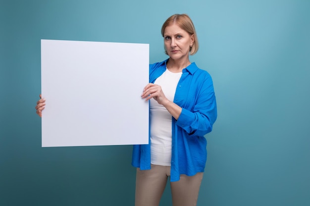 Middle age business concept mature woman with blank paper on blue background copy space