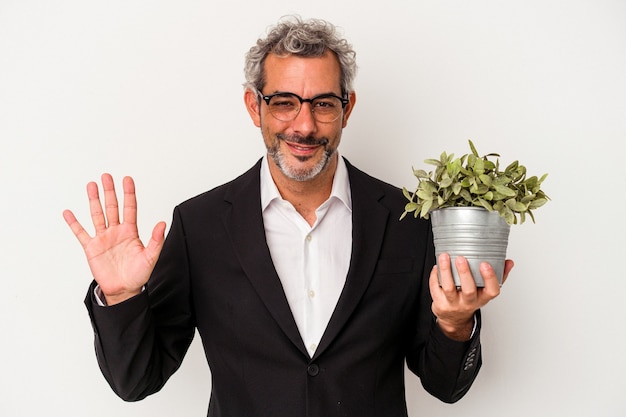 Middle age business man holding a plant isolated on white background  smiling cheerful showing number five with fingers.