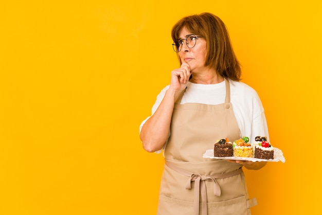 Middle age caucasian cook woman looking sideways with doubtful and skeptical expression