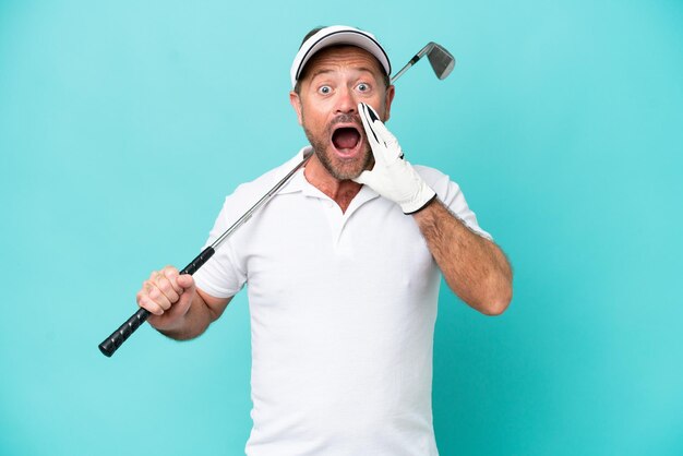 Middle age caucasian golfer player man isolated on blue background with surprise and shocked facial expression