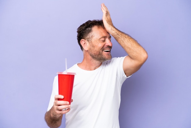 Middle age caucasian man holding soda isolated on purple background has realized something and intending the solution