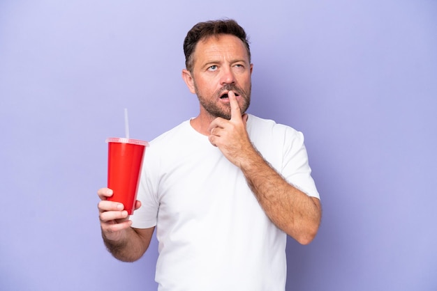 Middle age caucasian man holding soda isolated on purple background having doubts while looking up