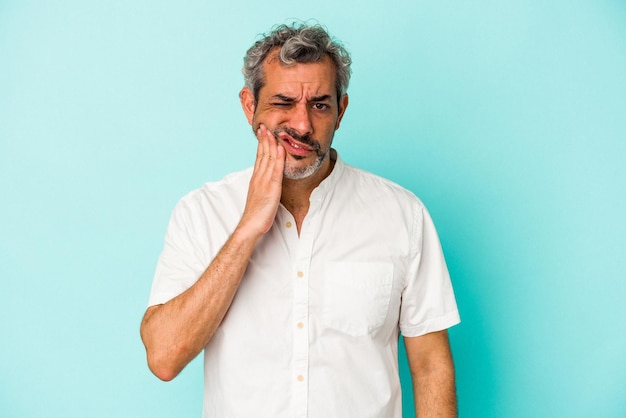 Photo middle age caucasian man isolated on blue background having a strong teeth pain molar ache