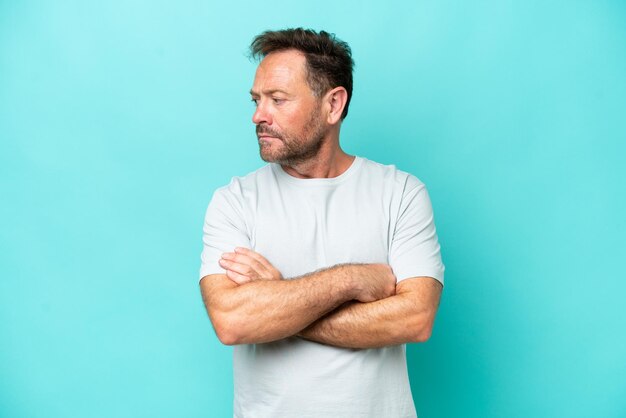 Photo middle age caucasian man isolated on blue background keeping the arms crossed