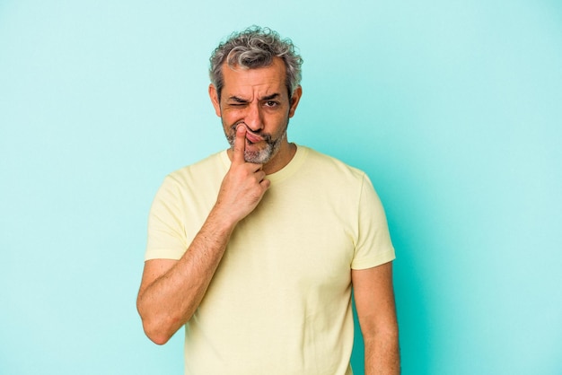 Middle age caucasian man isolated on blue background thinking and looking up being reflective contemplating having a fantasy