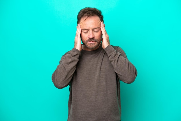 Middle age caucasian man isolated on blue background with headache