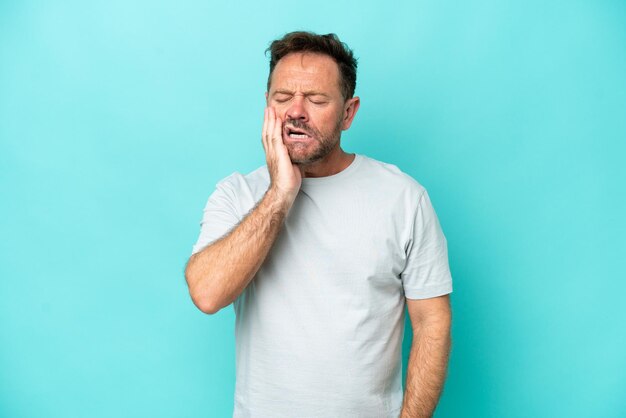 Middle age caucasian man isolated on blue background with toothache