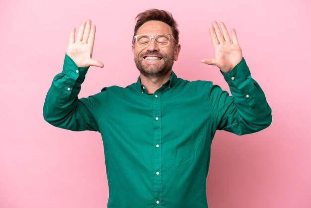 Middle age caucasian man isolated on pink background counting ten with fingers