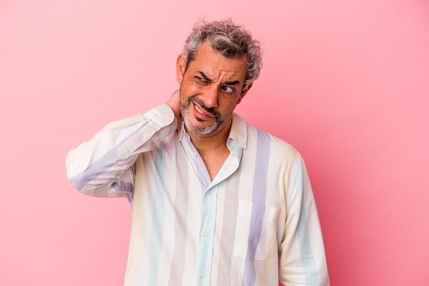 Middle age caucasian man isolated on pink background touching back of head thinking and making a choice