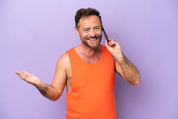 Middle age caucasian man isolated on purple background keeping a conversation with the mobile phone with someone