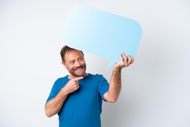 Middle age caucasian man isolated on white background holding an empty speech bubble and pointing it