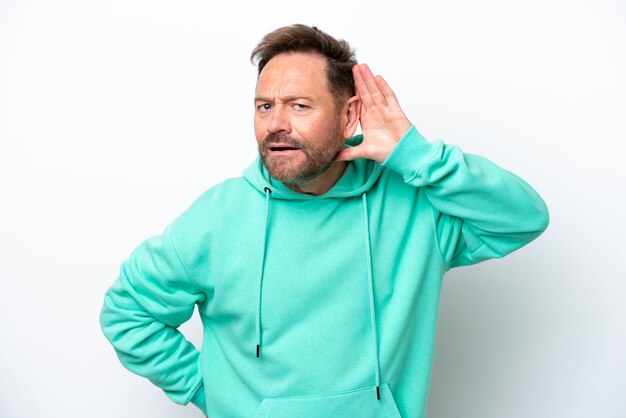 Middle age caucasian man isolated on white background listening to something by putting hand on the ear