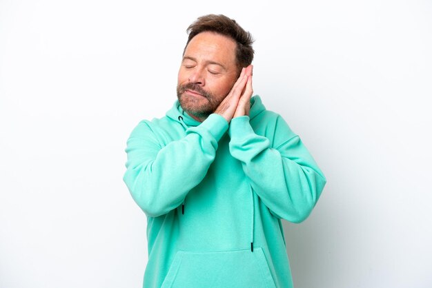 Middle age caucasian man isolated on white background making sleep gesture in dorable expression