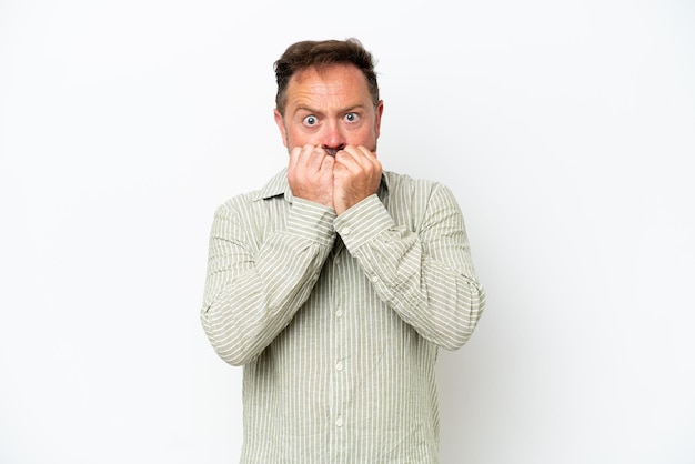 Middle age caucasian man isolated on white background nervous and scared putting hands to mouth