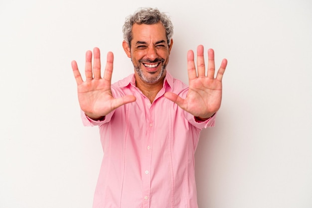 Белый мужчина средних лет на белом фоне показывает номер десять руками