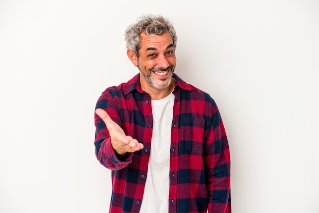 Middle age caucasian man isolated on white background stretching hand at camera in greeting gesture