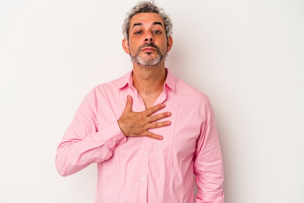 Middle age caucasian man isolated on white background  taking an oath, putting hand on chest.