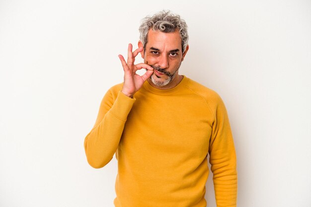 Middle age caucasian man isolated on white background  with fingers on lips keeping a secret.