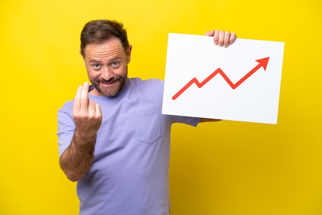 Middle age caucasian man isolated on yellow background holding a placard