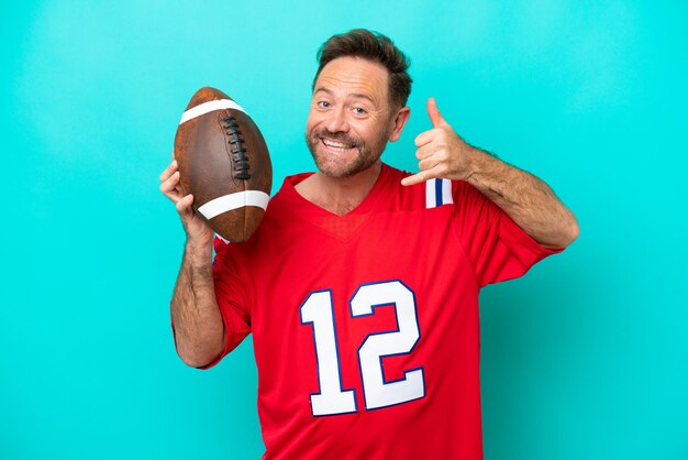 Middle age caucasian man playing rugby isolated on blue background