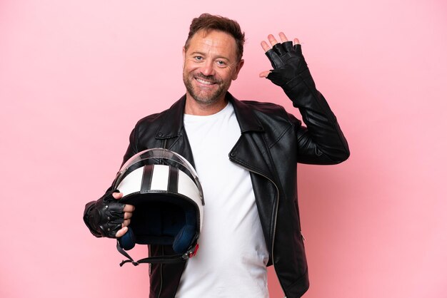 Photo middle age caucasian man with a motorcycle helmet isolated on pink background counting five with fingers