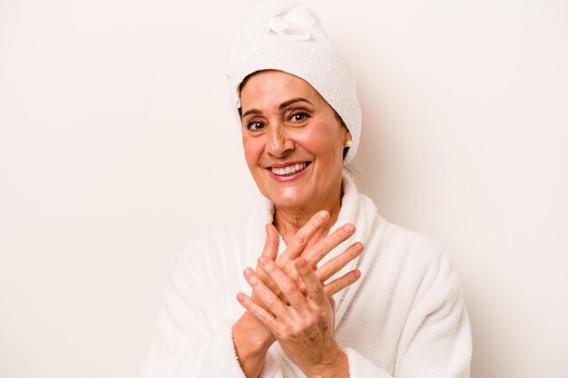 Middle age caucasian woman applying body cream isolated on white background