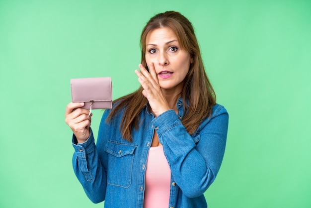 Middle age caucasian woman holding wallet over isolated background whispering something
