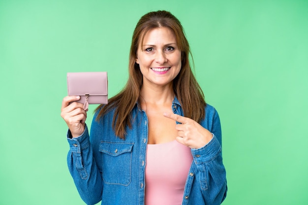 Middle age caucasian woman holding wallet over isolated background with surprise facial expression