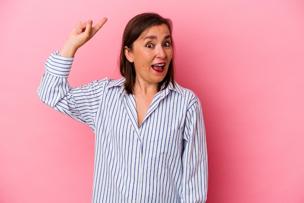 Middle age caucasian woman isolated on pink background having some great idea, concept of creativity.