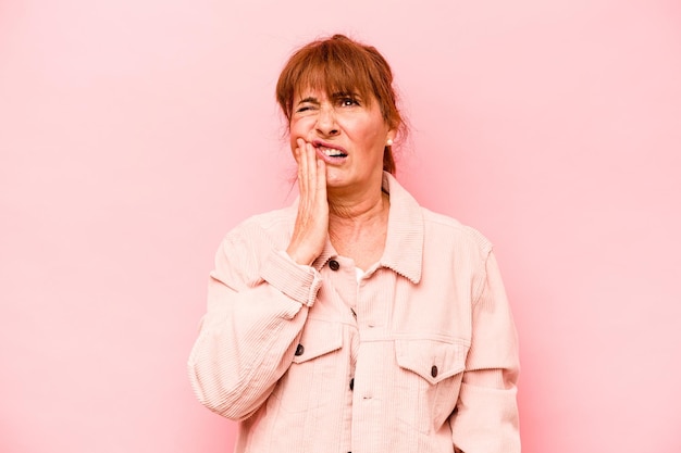 Middle age caucasian woman isolated on pink background having a strong teeth pain molar ache