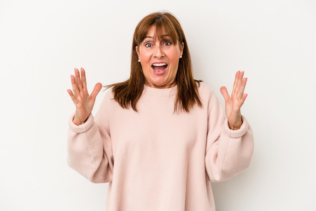 Middle age caucasian woman isolated on white background celebrating a victory or success, he is surprised and shocked.