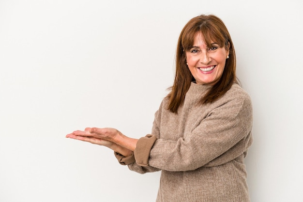 Middle age caucasian woman isolated on white background holding a copy space on a palm.