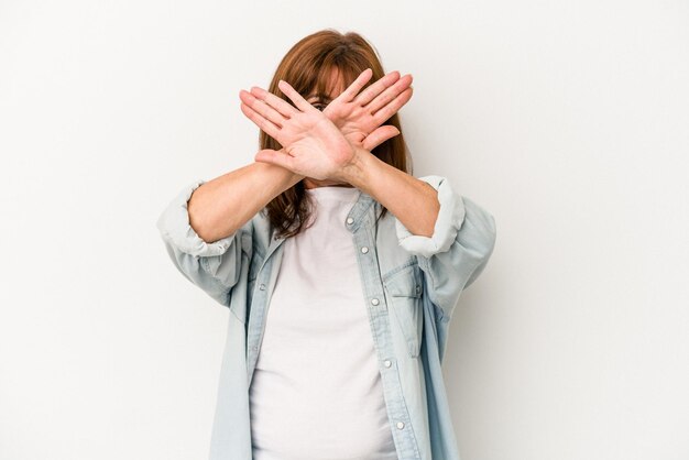 Middle age caucasian woman isolated on white background keeping two arms crossed, denial concept.