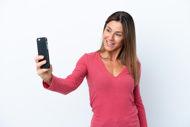 Middle age caucasian woman isolated on white background making a selfie