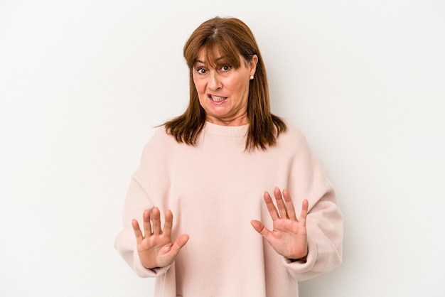 Middle age caucasian woman isolated on white background rejecting someone showing a gesture of disgust.