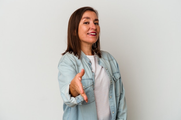 Middle age caucasian woman isolated on white background stretching hand at camera in greeting gesture.