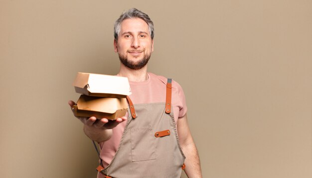 Uomo chef di mezza età con hamburger. concetto di barbecue