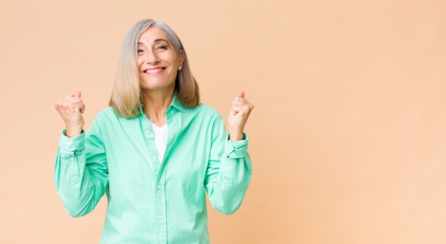 Foto bella donna di mezza età che si sente scioccata, eccitata e felice, ridendo e celebra il successo, dicendo wow!