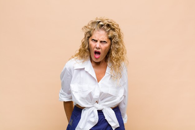 Foto donna fredda di mezza età con capelli ricci lunghi isolati