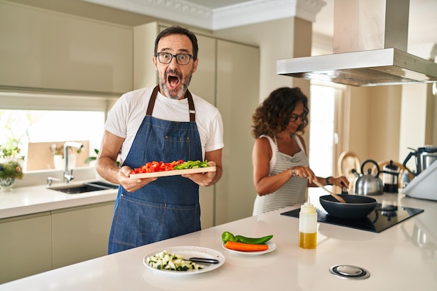 집에서 지중해 음식을 요리하는 중년 부부는 미친 듯이 축하하고 눈을 뜨고 흥분된 비명을 지르며 성공에 놀랐습니다.