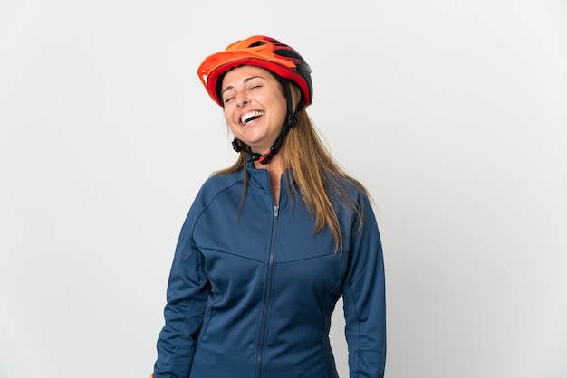 Middle age cyclist woman isolated on white background laughing