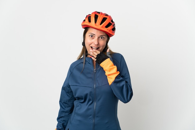 Middle age cyclist woman isolated on white wall happy and smiling covering mouth with hand