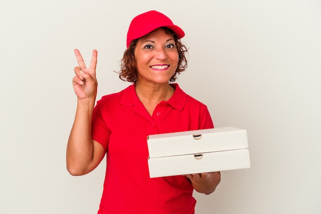 Middle age delivery woman taking pizzas isolated on white background showing number two with fingers.