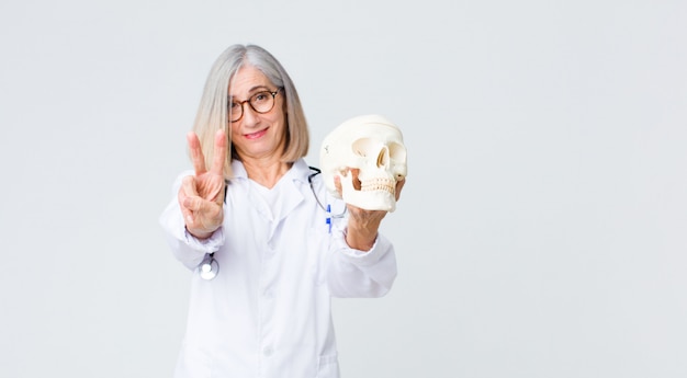 Middle age  doctor woman holding a skull