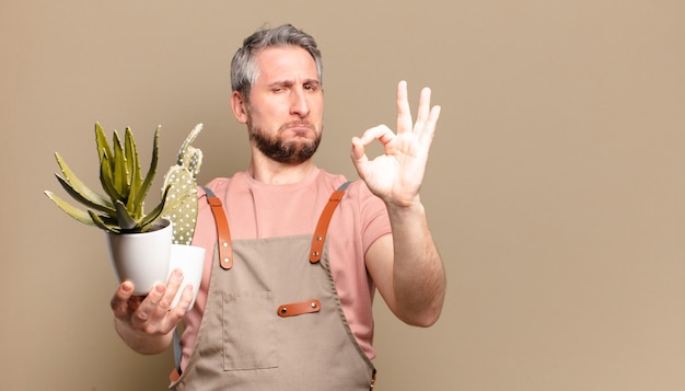 Middle age gardener man with cactus