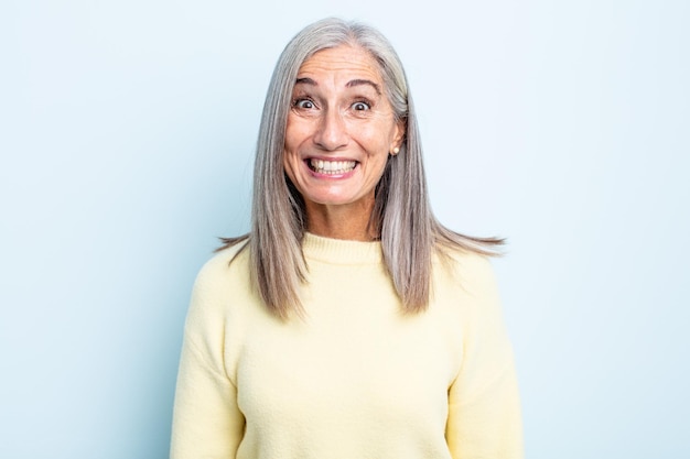 Middle age gray hair woman looking happy and goofy with a broad, fun, loony smile and eyes wide open