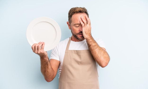 Middle age handsome man feeling bored, frustrated and sleepy after a tiresome. empty dish concept