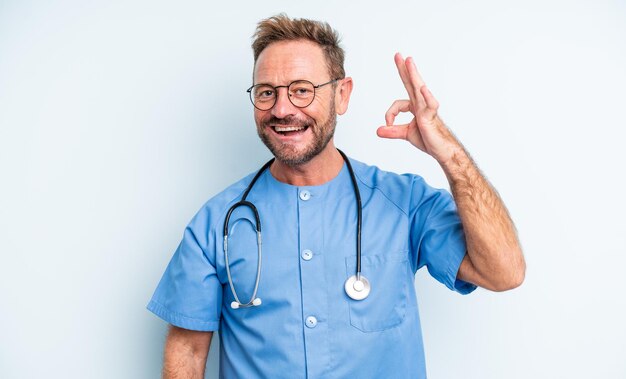 Middle age handsome man feeling happy showing approval with okay gesture nurse concept