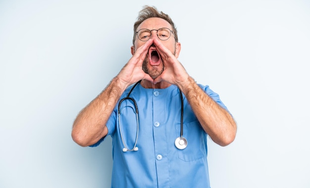 Middle age handsome man feeling happygiving a big shout out with hands next to mouth nurse concept