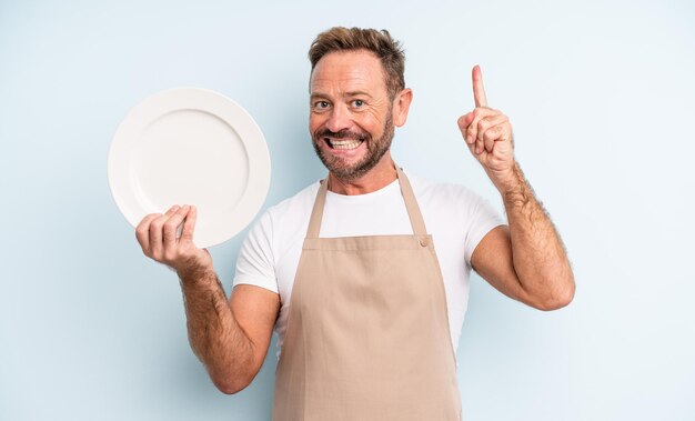 Middle age handsome man feeling like a happy and excited genius after realizing an idea. empty dish concept